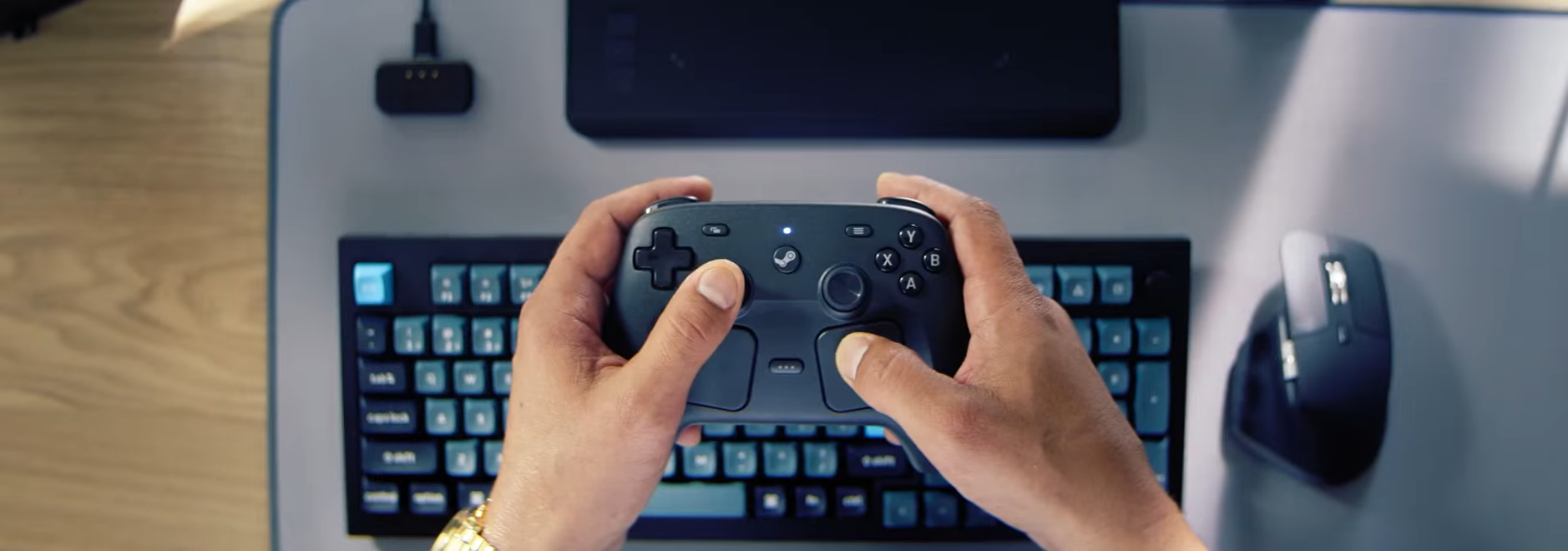The new Steam Controller held in the hands of a man
